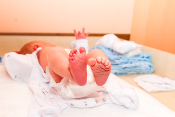 Fototapeta na wymiar Newborn's legs are small in the hands of parents