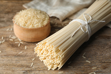 Raw rice noodles on wooden table, closeup