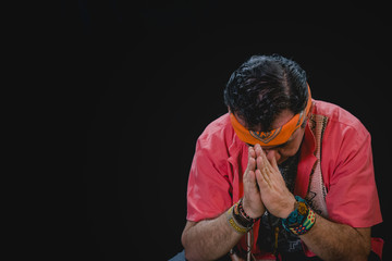 Shaman man, sorcerer, giving thanks duringPre-Hispanic ritual in Healing and cleaning with medicinal plants in Mexico, with black background