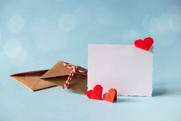 Valentine's day love letter mockup. Craft envelope with white blank card and hearts on blue...