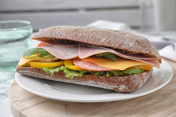Tasty sandwich with ham on kitchen table, closeup