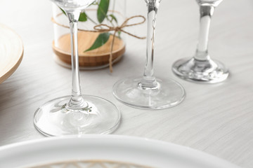 Glasses on white wooden table, closeup. Festive setting
