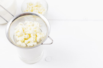 Homemade fermented beverage kefir with kefir grains in bowl on a white background, concept of natural fermented food and gut health