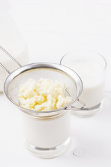 Homemade fermented beverage kefir with kefir grains in bowl on a white background, concept of natural fermented food and gut health