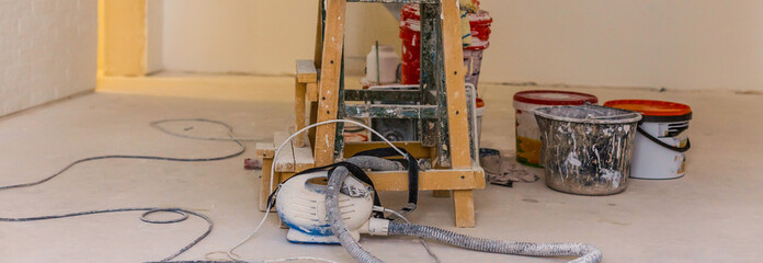 Ladder and set of tools for repair near grunge wall, closeup