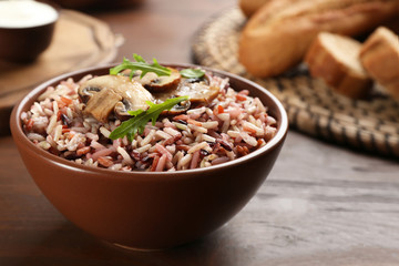 Delicious brown rice in bowl on wooden table
