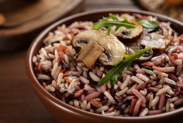 Delicious brown rice in bowl, closeup view