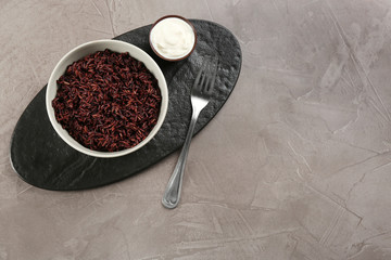 Tasty brown rice served on grey table, flat lay. Space for text