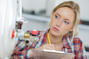 female plumber writing on clipboard