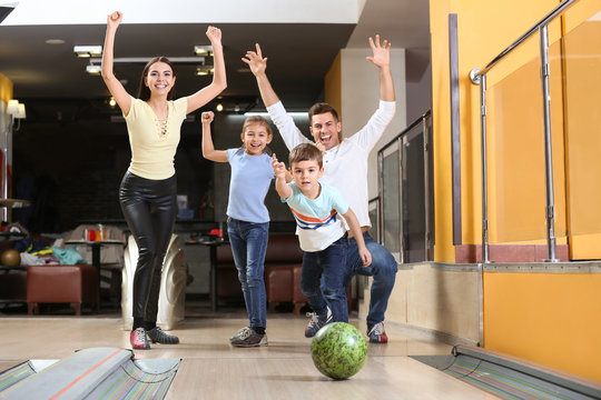 Happy Family Spending Time Together In Bowling Club