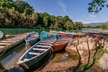 Obraz premium TAMUL, SAN LUIS POTOSI MEXICO - January 6, 2020:Colorful canoes on the Tamul river in Huasteca, these canoes will be used for the river tour and until you reach the waterfall
