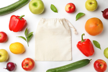 Cotton eco bag, fruits and vegetables on white background, top view