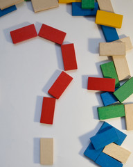 Colored dominoes are scattered. Colorful, wooden bars lie randomly.