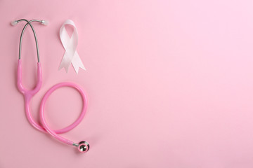 Obraz na płótnie Canvas Pink ribbon as breast cancer awareness symbol and stethoscope on color background, flat lay. Space for text