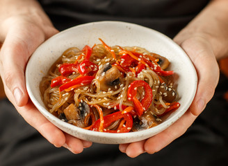 Starch (rice, potato) noodles with mushrooms and vegetables-bell peppers, carrots, onions, sesame seeds and soy sauce. Vegetarian dish. Delicious dinner in Asian (Chinese, Korean, Japanese) style - 320632996