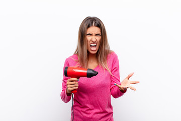young pretty woman looking angry, annoyed and frustrated screaming wtf or what‚Äôs wrong with...