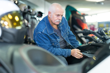 senior customer checking a motorbike