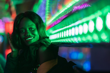 Cheerful black woman on funfair