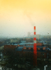 Industrial chimney through rain drops background