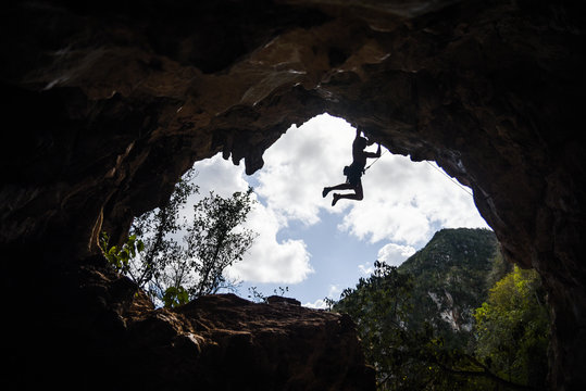 A man rock climbing in a cave. 