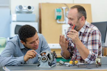 apprentice and teacher in electronic class