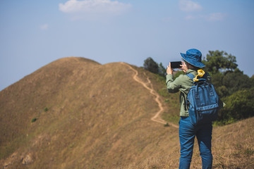 Asian woman traveler backpack And wearing a jean hat Taking pictures