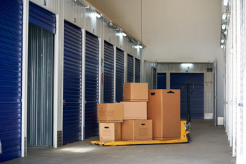 Inside industrial self storage building for rental with blue locked doors