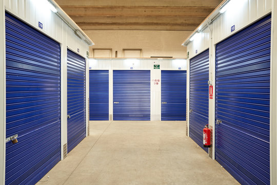Inside industrial self storage building for rental with blue locked doors