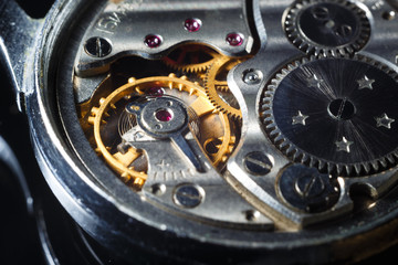 Old wrist watch with metal gears and cogwheels. Detail of watch machinery, macro.