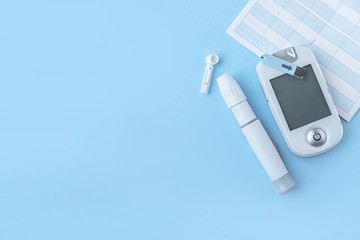 Diabetes. Self-monitoring of blood glucose. Lancet, glucometer, control book on a blue background....