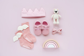 Pink socks, shoes, cotton crown and toy bear. Set of baby stuff and accessories for girl on pastel background. Baby shower concept.  Fashion newborn. Flat lay, top view