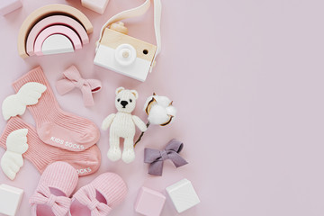 Set of baby stuff and accessories for girl on pastel background. Pink socks, shoes and toys. Baby shower concept.  Fashion newborn. Flat lay, top view