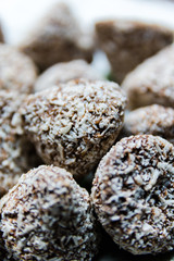 Chocolate candies in coconut shavings close-up, selective focus