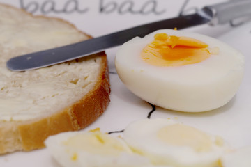 half a boiled egg and bread with butter