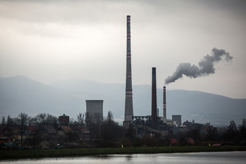 View from afar the city and a factory chimney with lots of smoke and smog. Europe, landscape Slovakia, Novaky. Chemical factory. Abstract. Global warming of the earth.