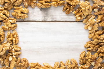 Scattered walnuts on wooden table, stock photo.