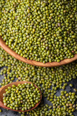 Mung bean, green moong in a wooden plate and spoon, on black metallic vintage background. Copy...