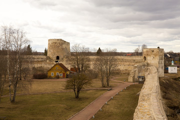 The panorama of the medieval fortress was made on a cloudy spring day. Izborsk, Pskov Region, Russia.