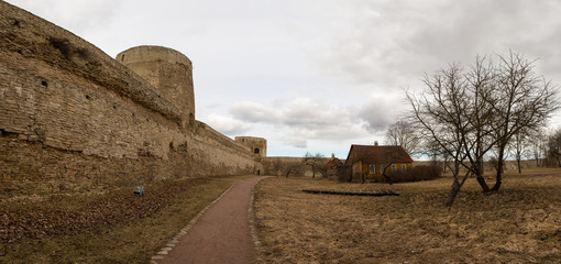 The panorama of the medieval fortress was made on a cloudy spring day. Izborsk, Pskov Region, Russia.