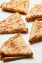 Folded pancakes on white marble background
