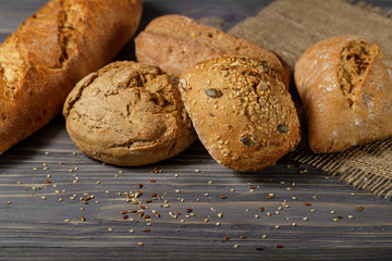 Fresh bread rolls  and baguette closeup  on old wooden table. Rustic concept