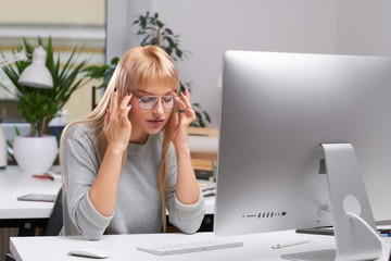 Beautiful blond office worker feels very tired at her new job in the office.