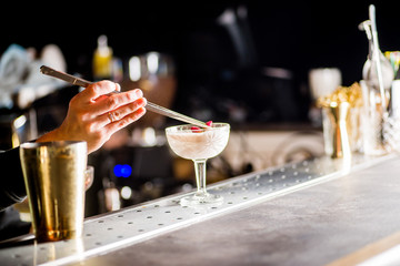 bartender is preparing a cocktail. Bartender pours a cocktail