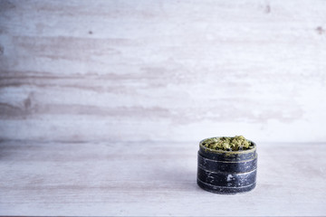 Recreational marijuana and metal grinder on a white stone background after Illinois passes a law to...
