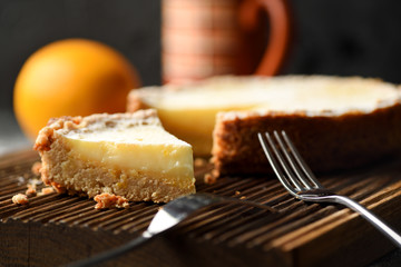Healthy gluten free low sugar dessert. Open lemon pie with wholegrain oatmeal crust on dark oak cutting board