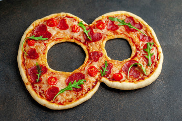 Pizza in the form of 8 for the International Women's Day on the eighth of March on a stone background. with copy space for your text. March 8th holiday concept.
