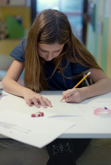 young girl focused on drawing at home