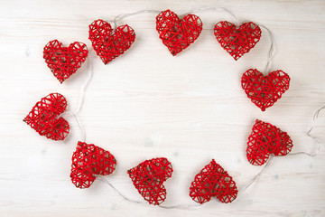 Red lights in the shape of the beautiful hearts on the light wooden background. St Valentine's concept with copy space.