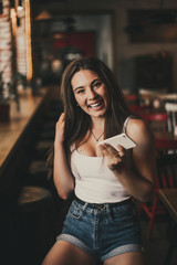 Beautiful woman posing for the camera sitting in a cafe.