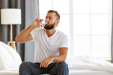 young healthy man drinking water in morning